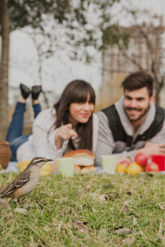 Pareja jugando con un pájaro en los jardines del hotel rural Xerete